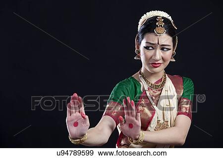 Stock Photo - Beautiful woman performing Bharatanatyam on black background. Fotosearch