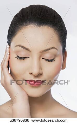 Stock Photograph - Beautiful woman with hand on cheek over white background . Fotosearch
