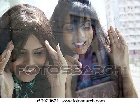 Beautiful women peeking through window View Large Photo Image Stock Image - Beautiful women peeking through window . Fotosearch