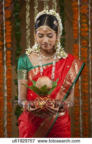 Stock Photo - Beautiful young bride holding kalash . Fotosearch