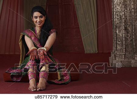 Stock Photo - Beautiful young Indian woman showing her hands with henna tattoo . Fotosearch