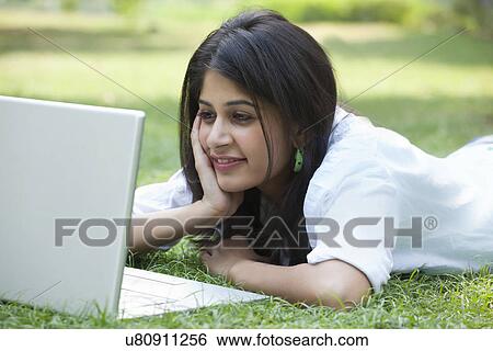 Beautiful young smiling woman using laptop on campus View Large Photo Image Stock Photograph - Beautiful young smiling woman using laptop on campus . Fotosearch