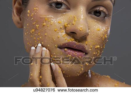 Beautiful young woman applying scrub on face View Large Photo Image Stock Photograph - Beautiful young woman applying scrub on face . Fotosearch
