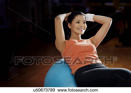Beautiful young woman doing abdominal exercise on a fitness ball View Large Photo Image Stock Photo - Beautiful young woman doing abdominal exercise on a fitness ball . Fotosearch