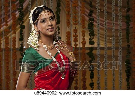 Stock Image - Beautiful young woman in traditional sari looking away . Fotosearch