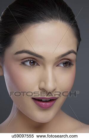 Beautiful young woman looking away over colored background View Large Photo Image Stock Photography - Beautiful young woman looking away over colored background . Fotosearch