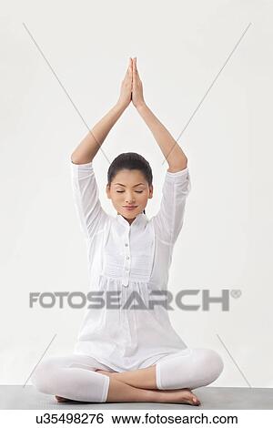 Stock Photograph - Beautiful young woman meditating . Fotosearch