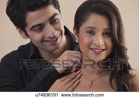 Beautiful young woman receiving necklace from man View Large Photo Image Stock Image - Beautiful young woman receiving necklace from man . Fotosearch