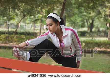 Beautiful young woman stretching in park View Large Photo Image Stock Photograph - Beautiful young woman stretching in park . Fotosearch