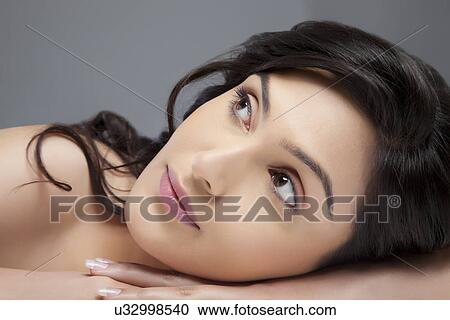 Beautiful young woman thinking about something over colored background View Large Photo Image Stock Image - Beautiful young woman thinking about something over colored background . Fotosearch