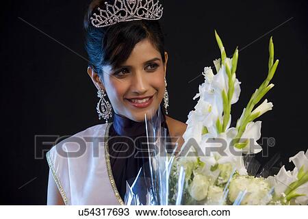 Stock Image - Beauty queen with a bouquet of flowers . Fotosearch