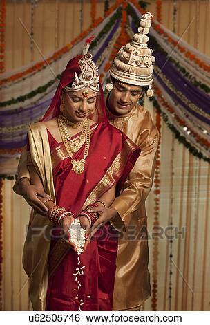 Bengali bride and groom making an offering View Large Photo Image Stock Photograph - Bengali bride and groom making an offering . Fotosearch