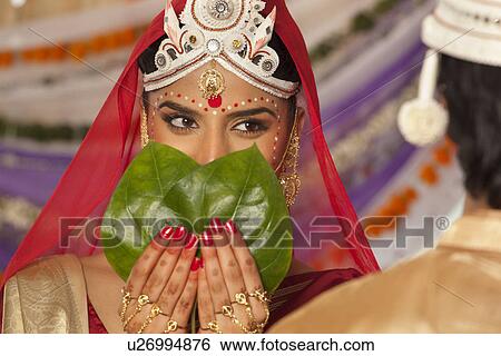 Bengali bride hiding her face from the groom View Large Photo Image Stock Photograph - Bengali bride hiding her face from the groom . Fotosearch