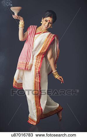 Stock Image - Bengali woman doing a dhunuchi dance . Fotosearch