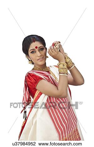 Bengali woman holding a conch shell View Large Photo Image Stock Image - Bengali woman holding a conch shell. Fotosearch