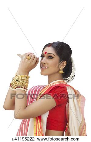 Stock Image - Bengali woman holding a conch shell . Fotosearch