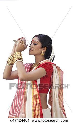 Stock Image - Bengali woman holding a conch shell. Fotosearch