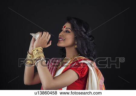 Bengali woman holding a conch shell View Large Photo Image Stock Photo - Bengali woman holding a conch shell. Fotosearch