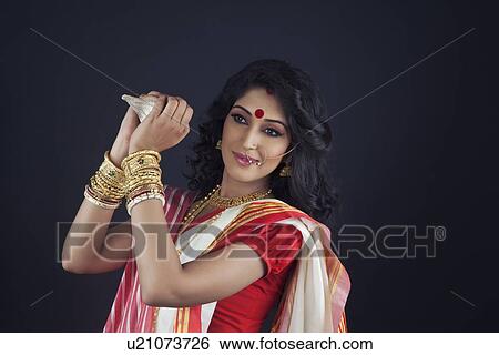 Bengali woman holding a conch shell View Large Photo Image Stock Photograph - Bengali woman holding a conch shell. Fotosearch