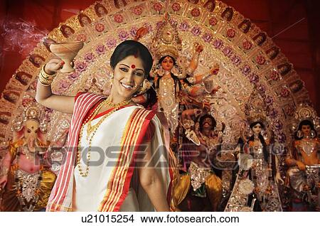 Picture - Bengali woman holding a dhunuchi. Fotosearch