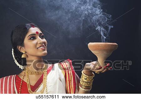 Bengali woman holding a dhunuchi View Large Photo Image Stock Image - Bengali woman holding a dhunuchi . Fotosearch