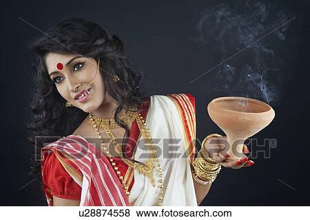 Stock Photo - Bengali woman holding a dhunuchi. Fotosearch