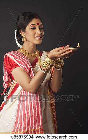 Picture - Bengali woman holding a diya. Fotosearch