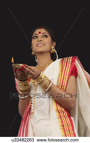 Stock Image - Bengali woman holding a diya. Fotosearch