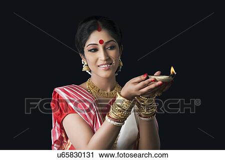 Stock Image - Bengali woman holding a diya. Fotosearch