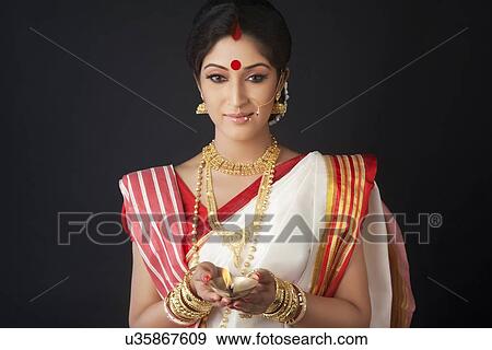 Stock Photo - Bengali woman holding a diya. Fotosearch