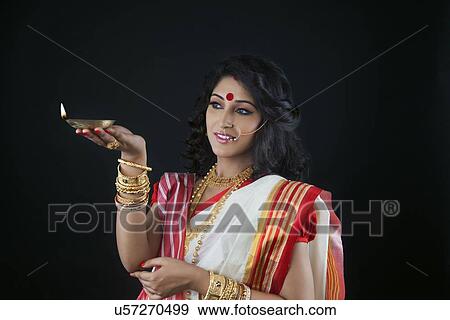 Bengali woman holding a diya View Large Photo Image Stock Photo - Bengali woman holding a diya. Fotosearch