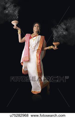 Bengali woman holding dhunuchis View Large Photo Image Stock Photo - Bengali woman holding dhunuchis. Fotosearch