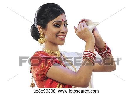 Stock Photo - Bengali woman holding on a conch shell . Fotosearch