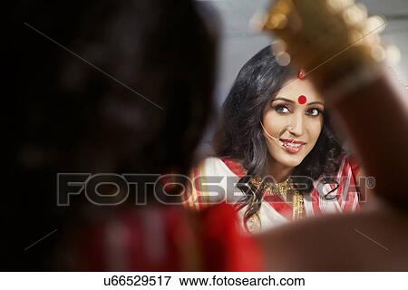 Bengali woman looking at herself in the mirror View Large Photo Image Stock Photo - Bengali woman looking at herself in the mirror . Fotosearch