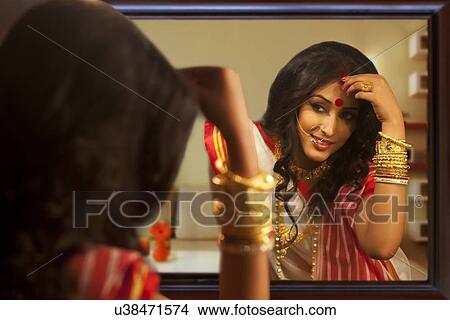 Bengali woman putting sindoor on her forehead View Large Photo Image Picture - Bengali woman putting sindoor on her forehead. Fotosearch