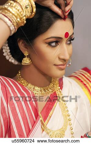 Bengali woman putting sindoor on her forehead View Large Photo Image Picture - Bengali woman putting sindoor on her forehead. Fotosearch