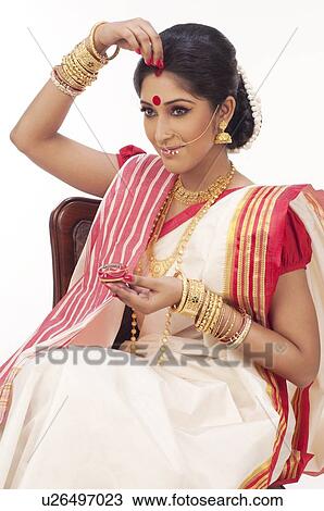 Bengali woman putting sindoor on her forehead View Large Photo Image Stock Image - Bengali woman putting sindoor on her forehead . Fotosearch