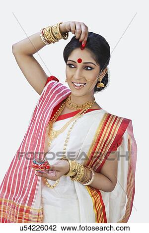 Bengali woman putting sindoor on her forehead View Large Photo Image Stock Image - Bengali woman putting sindoor on her forehead. Fotosearch