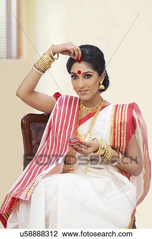 Bengali woman putting sindoor on her forehead View Large Photo Image Stock Image - Bengali woman putting sindoor on her forehead. Fotosearch