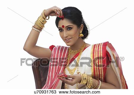 Bengali woman putting sindoor on her forehead View Large Photo Image Stock Image - Bengali woman putting sindoor on her forehead . Fotosearch