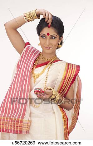 Bengali woman putting sindoor on her forehead View Large Photo Image Stock Photo - Bengali woman putting sindoor on her forehead . Fotosearch