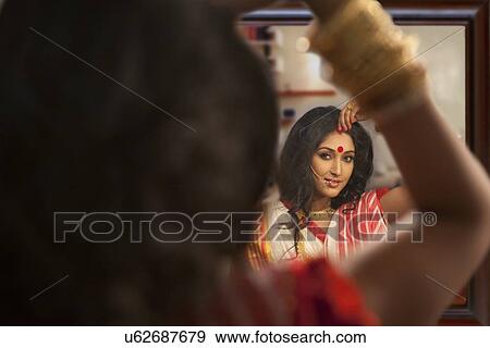 Bengali woman putting sindoor on her forehead View Large Photo Image Stock Photo - Bengali woman putting sindoor on her forehead. Fotosearch