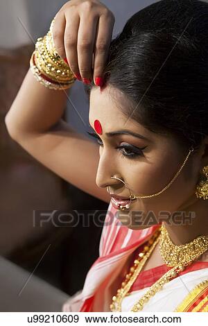 Bengali woman putting sindoor on her forehead View Large Photo Image Stock Photo - Bengali woman putting sindoor on her forehead. Fotosearch