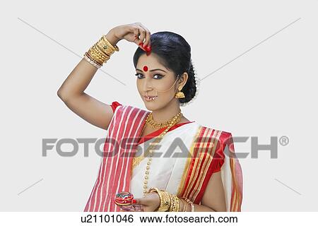 Bengali woman putting sindoor on her forehead View Large Photo Image Stock Photograph - Bengali woman putting sindoor on her forehead. Fotosearch