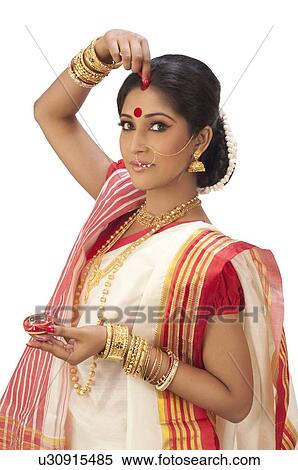 Bengali woman putting sindoor on her forehead View Large Photo Image Stock Photography - Bengali woman putting sindoor on her forehead. Fotosearch