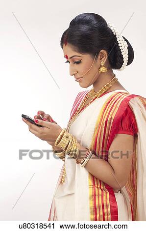 Bengali woman reading an sms on a mobile phone View Large Photo Image Stock Image - Bengali woman reading an sms on a mobile phone . Fotosearch
