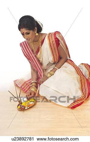 Stock Image - Bengali woman sitting with puja thali. Fotosearch