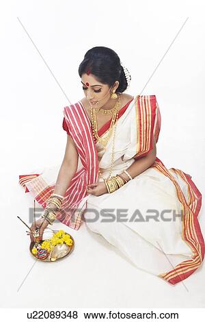 Stock Photo - Bengali woman sitting with puja thali. Fotosearch
