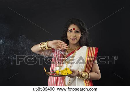 Stock Image - Bengali woman with a puja thali . Fotosearch