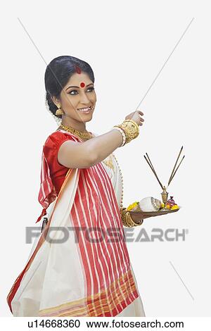 Stock Image - Bengali woman with puja thali smiling. Fotosearch